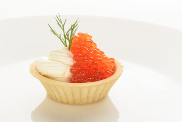red caviar in a basket of dough with cream cheese on a white plate