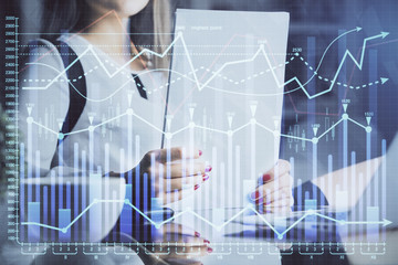 Double exposure of hands making notes with forex chart huds. Stock market concept.