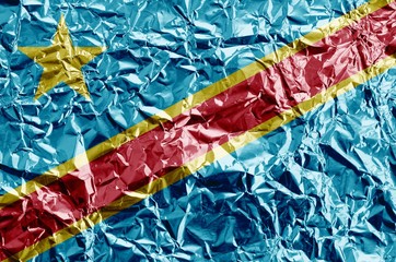 Democratic Republic of the Congo flag depicted in paint colors on shiny crumpled aluminium foil closeup. Textured banner on rough background