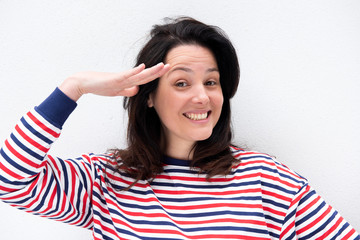 Close up young woman smiling and hand to head salute gesture