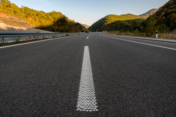 Empty silent Asphalt highway road with close up white markings