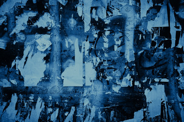 Blue color grunge backdrop. Scraps of old paper posters on the wall