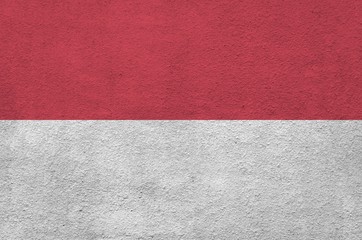 Indonesia flag depicted in bright paint colors on old relief plastering wall. Textured banner on...