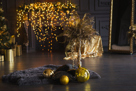 Golden christmas decorations in dark interior. Disco balls and new year lamp garlands