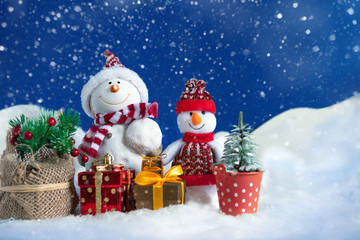 Snowman in a snowdrift with gifts for Christmas and New year