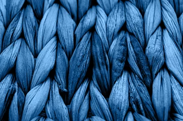 Wall murals Macro photography Rustic natural wicker texture toned in classic blue monochrome color. Braided pattern macro photography.