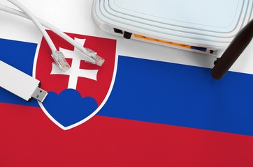 Slovakia flag depicted on table with internet rj45 cable, wireless usb wifi adapter and router....