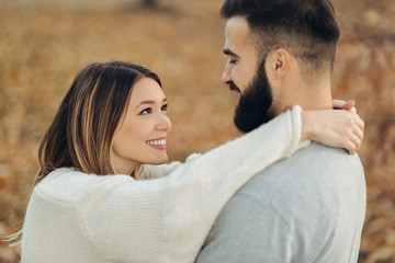 Happy couple standing face to face in the park and enjoying in autumn day
