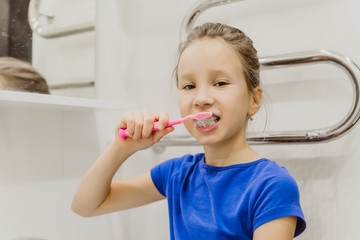 A child brushes his teeth with a toothbrush in the bathroom.  prevention of caries. the concept of hygiene and cleanliness of the oral cavity. toothpaste on the toothbrush
