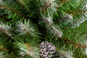 Abstract background. Fragments of branches and a cone of an artificial Christmas tree. Selective focus. Blank for lettering or design.