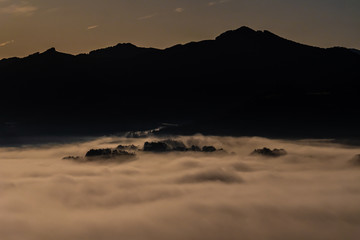 Niebla baja atardecer desde una montaña
