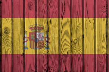Spain flag depicted in bright paint colors on old wooden wall. Textured banner on rough background
