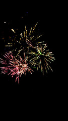 Colorful traditional fireworks in dark night sky, isolated on black