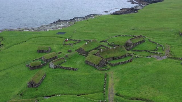 Aerial wiev of fishing village in Koltur island. Faroe Islands. Green roof houses. Nordic natural landscape.