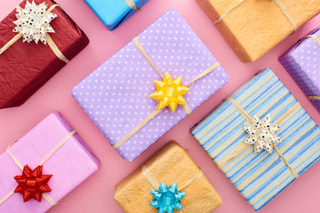 top view of wrapped gift boxes with bows on pink