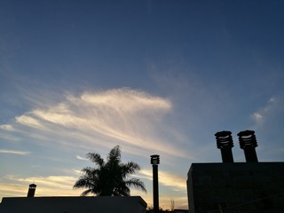 smoke from chimney on sunset background of sky