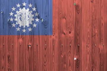 Myanmar flag depicted in bright paint colors on old wooden wall. Textured banner on rough background