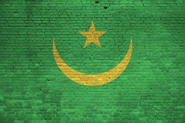 Mauritania flag depicted in paint colors on old brick wall. Textured banner on big brick wall...