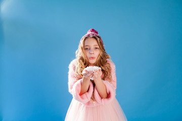 Beautiful fashionable girl in winter snow cap blue background