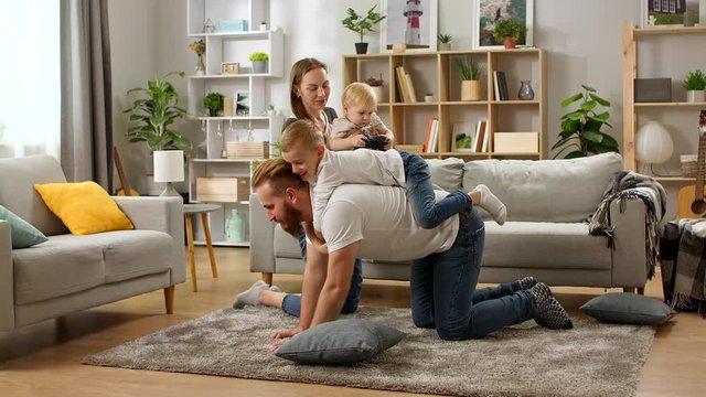Happy funny family playing with father at home