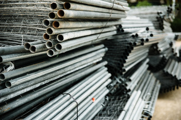 Obraz premium Old steel pipes stacked in an industrial warehouse.