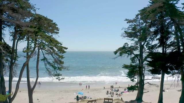 People enjoying a warm summer day on the beach in Santa Cruz, California. Warm sand and cool water is all you need for a perfect summer beach day with family and friends.