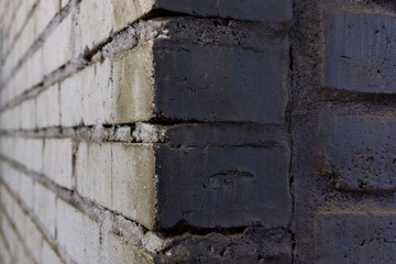 corner of a brick wall with rough masonry