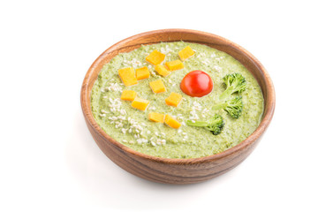 Green broccoli cream soup in wooden bowl isolated on white background. side view.