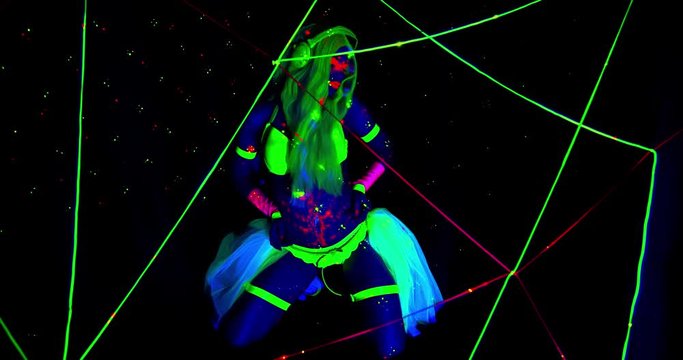 Colorful bright lights and a young woman in glowing ultraviolet clothes, 4k