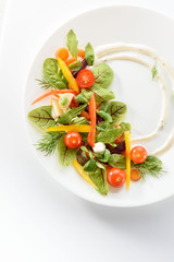 micro-greens and vegetables salad on a white plate