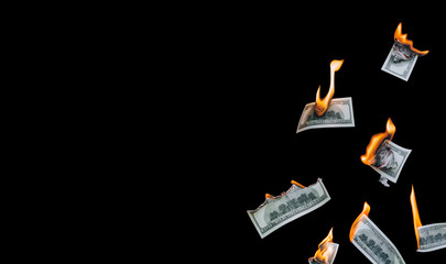 Several 100 dollar bills, falling down, burn on a black background. The concept of bankruptcy,...