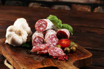 thinly sliced salami on a wooden texture on the background.