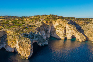 Aerial view of Blue grotto, cliffs. Blue clear sky with clouds, winter, rocks, sunny day. Malta island