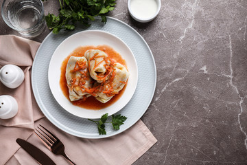 Delicious cabbage rolls served on grey marble table, flat lay