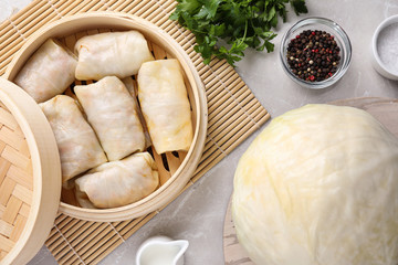 Delicious cabbage rolls served on light grey marble table, flat lay
