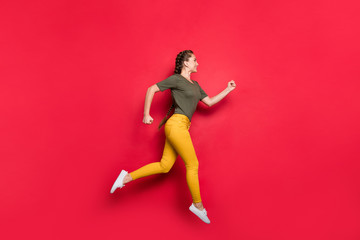 Fototapeta na wymiar Full size profile photo of millennial lady jumping high sports competition marathon participant running speed wear casual yellow pants green t-shirt isolated red color background