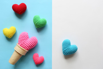 Pink handmade crochet heart in waffle cup on colorful background for valentines day