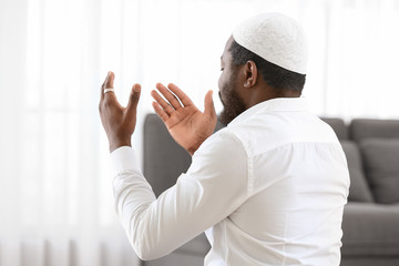 African-American Muslim man praying in office