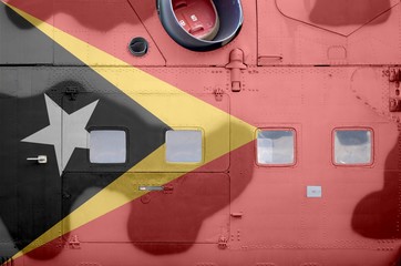 Timor Leste flag depicted on side part of military armored helicopter closeup. Army forces aircraft...