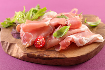 prosciutto ham and basil on wooden board