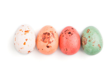 Four chocolate eggs candies isolated on white background. close up, top view.