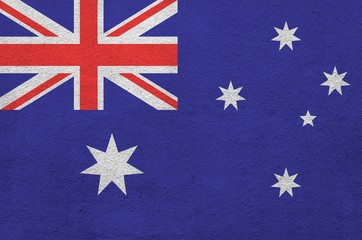 Australia flag depicted in bright paint colors on old relief plastering wall. Textured banner on...