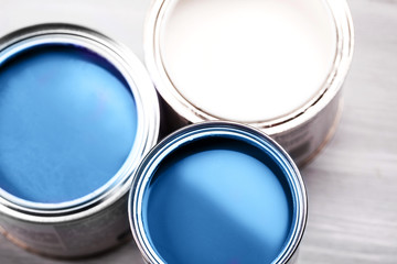 Several opened cans with paint inside. Blue and white colors of paint. Close up.