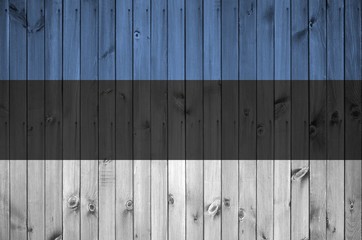 Estonia flag depicted in bright paint colors on old wooden wall. Textured banner on rough background