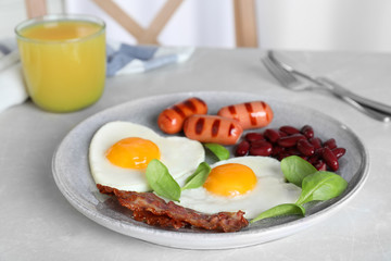Tasty breakfast with heart shaped fried eggs served on kitchen table