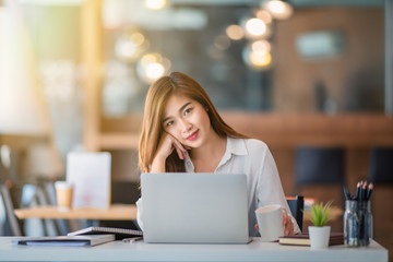 Portrait of young business woman working and thinking in the office	