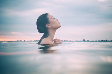 Asian model in the water enjoying a wellness spa.