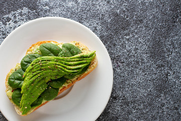 Fresh avocado sandwich with humus. Vegeterian food. Whole foods. White  concrete background. Top view. Empty space. 