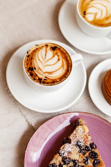 Cozy and romantic. Winter hot cappuccino drink in white cups. Delicious french pastry for breakfast.