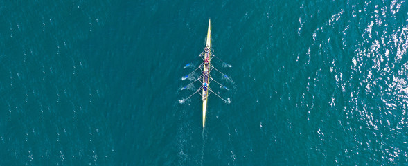 Aerial drone top panoramic view of sport canoe rowing synchronous athletes competing in tropical...